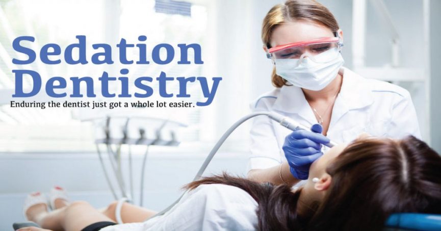 a female dentist wearing a white coat, a mask, safety glasses, and gloves, performing a dental procedure on a patient who is lying back in a dental chair. The background is blurred, focusing attention on the dentist and the patient. The text overlay on the image reads, "Sedation Dentistry: Enduring the dentist just got a whole lot easier."