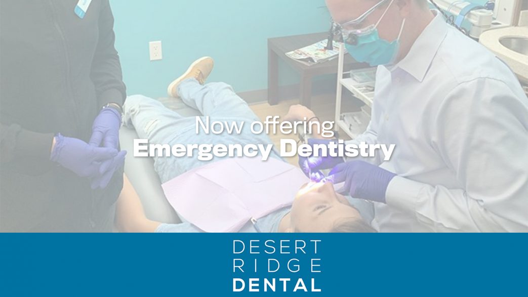 a dentist and a dental assistant performing a procedure on a patient who is lying in a dental chair. The dentist is wearing a mask and gloves, and using a dental tool with a light. The assistant is also wearing gloves and standing nearby. The text overlay on the image reads "Now offering Emergency Dentistry." At the bottom of the image, there is a blue banner with the logo and name "Desert Ridge Dental."